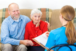 nurse and elder couple having a conversation